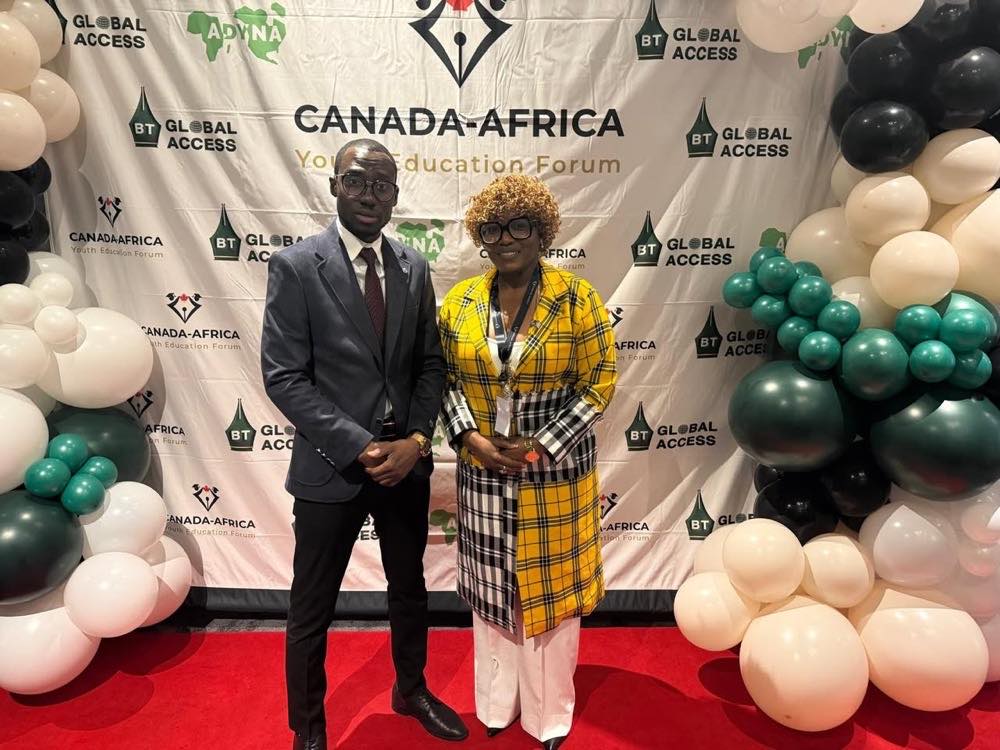 Deux délégués côte à côte sur le tapis rouge devant la toile de fond du forum, portant tous deux un cordon de conférence.